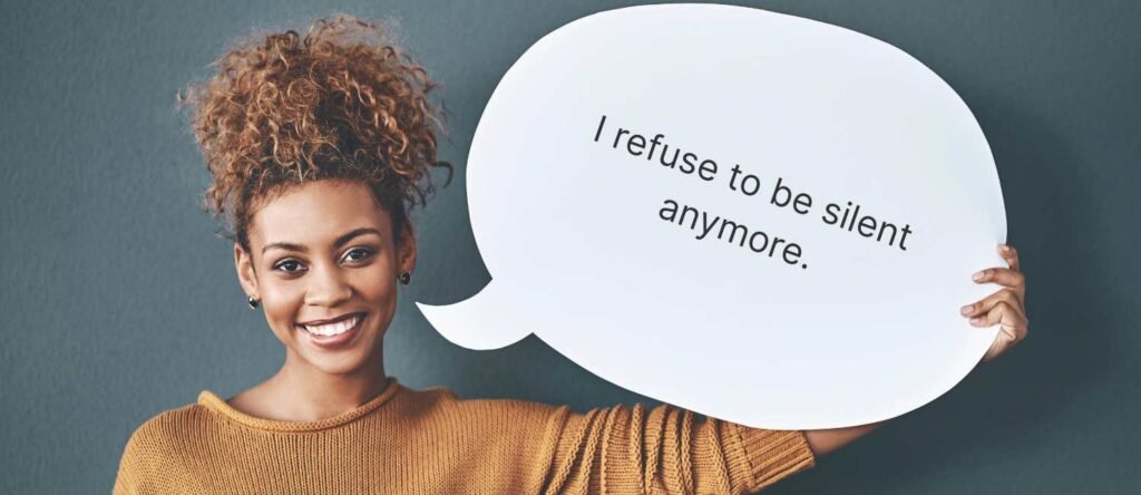 A young woman holds a speech bubble that says “I refuse to be silent anymore,” symbolizing empowerment and speaking out against workplace harassment.