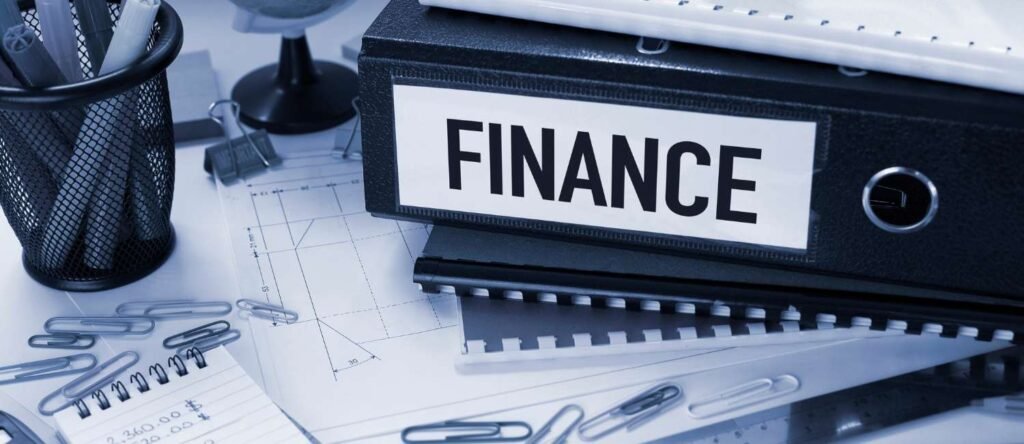 Stack of financial documents and reports on a desk with charts and figures