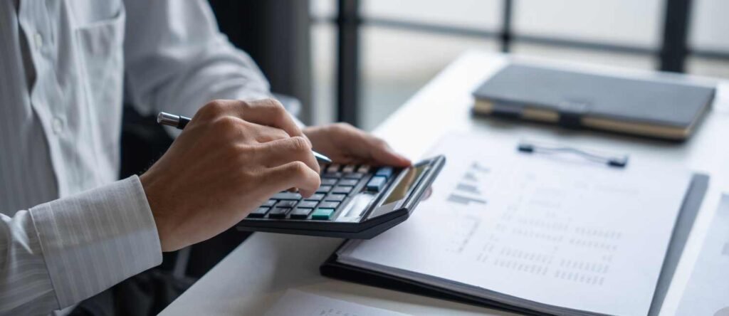 Close-up of financial documents and spreadsheets showing calculations for compliance exposure