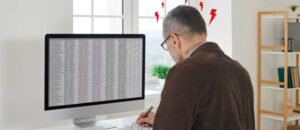 Business owner stressed while managing HR data in spreadsheets highlighting inefficiency and HR risks for UK SMEs