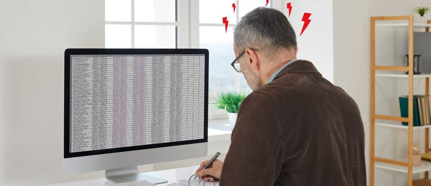 Business owner stressed while managing HR data in spreadsheets highlighting inefficiency and HR risks for UK SMEs