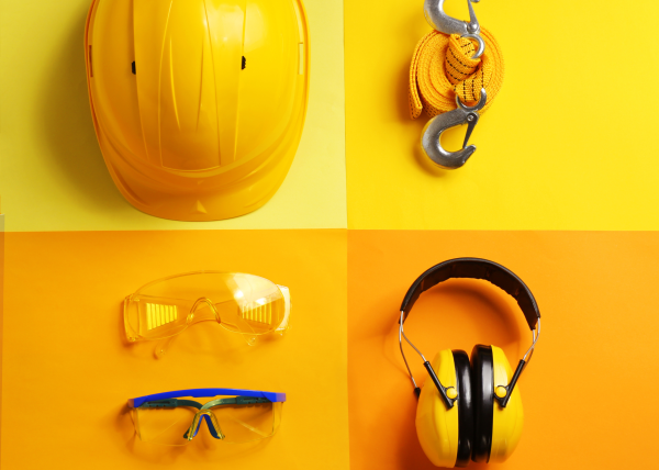 Essential PPE gear including safety helmet, harness, goggles, and earmuffs – workplace safety equipment.